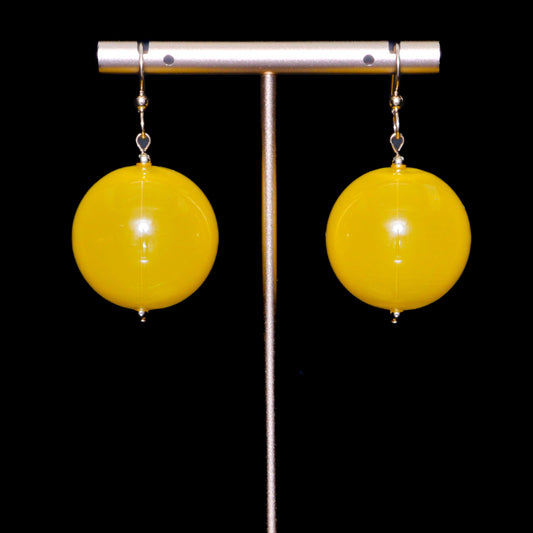 Yellow handblown glass earrings against a black background