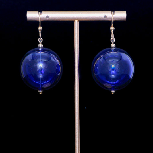 Cobalt blue handblown glass earrings against a black background