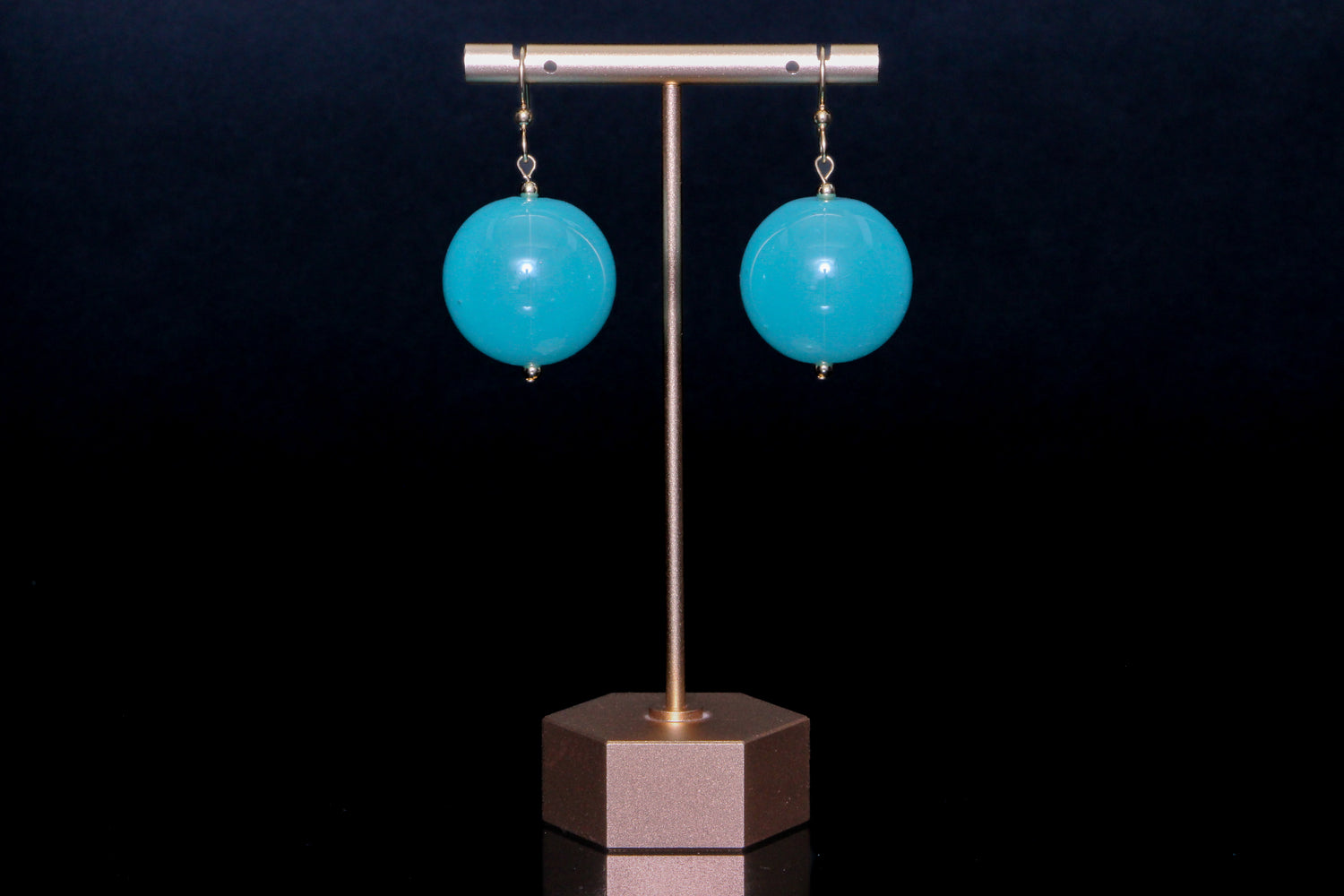 Turquoise glass earrings on a black background