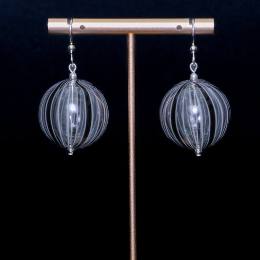 Black and white handblown glass earrings against a black background