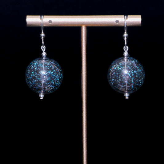 Sparkly black handblown glass earrings against a black background